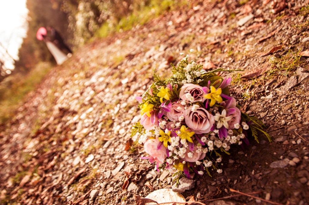 Ramo de boda con la pareja al fondo desenfocada.
